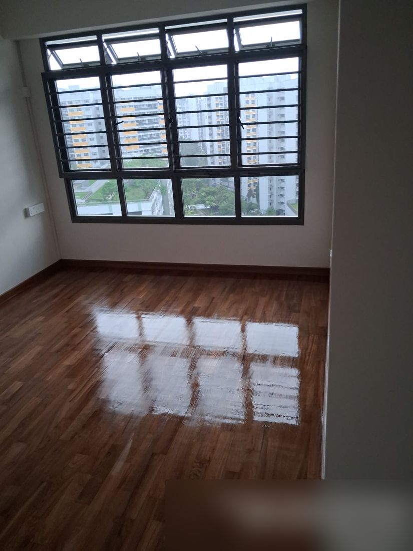 Strip parquet bedroom after gloss varnish, by a large window